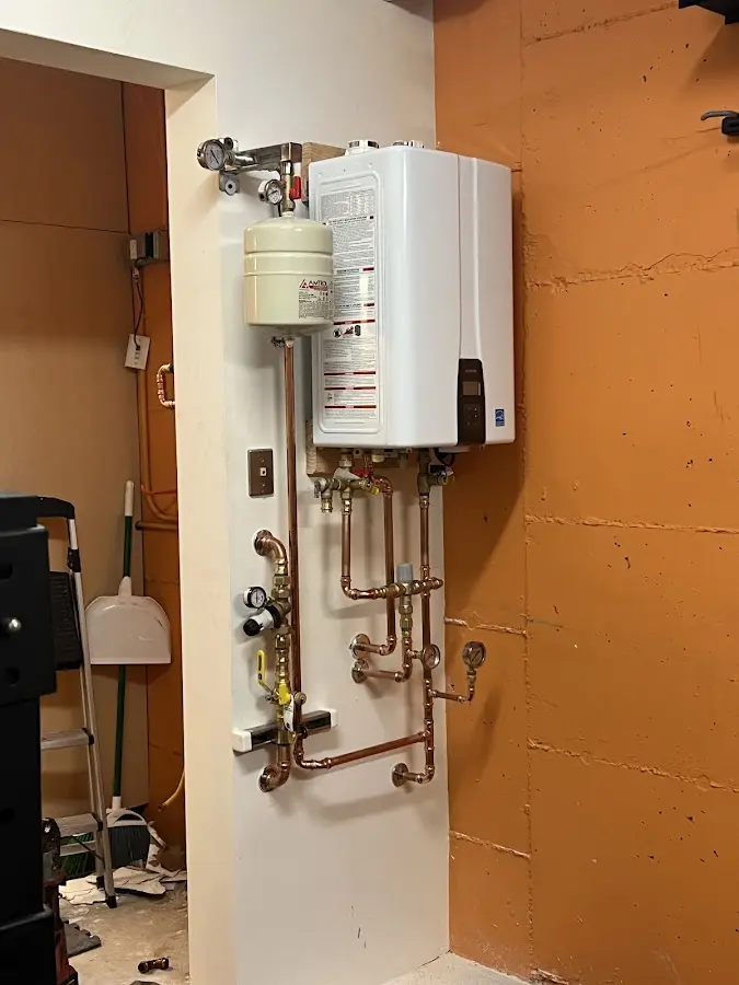 Plumbing technician inspecting water heater connections in Las Flores